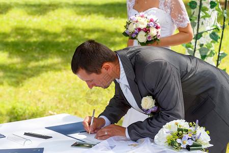 新郎在公园中与背景新娘签图片
