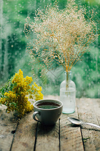 浪漫的背景与一杯茶鲜花和打开的书在木桌咖啡杯书和桌上图片