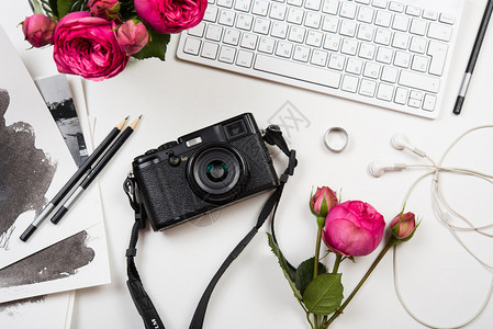 现代计算机键盘粉红花和白色桌上的照相机自由职业图片