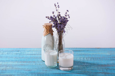 绿松石木桌面上的一瓶和两杯薰衣草鲜牛奶图片