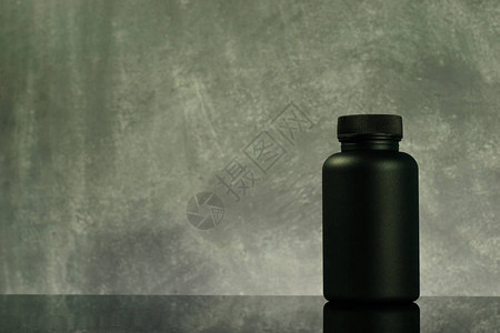 黑色玻璃桌上的黑瓶子药片图片