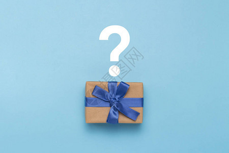 蓝色背景上有蓝色丝带和问号的礼品盒图片