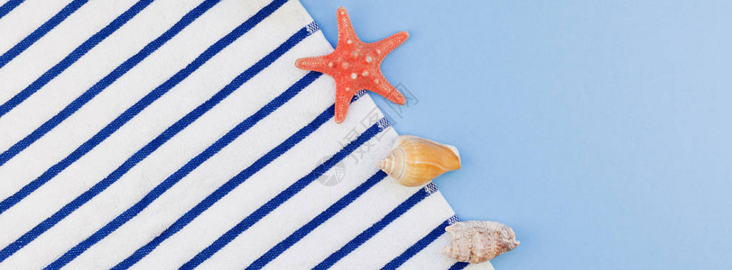 海边毛巾海贝壳和海星以面纸蓝底色背景图片