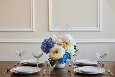 白板金刀和叉子水晶眼镜和在餐厅木制餐桌的图片