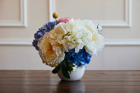 在家里的木制桌子上用白色花瓶装在白花瓶中图片