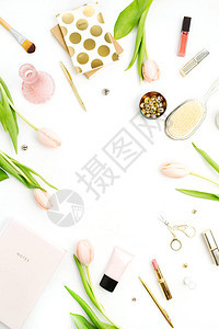 白色背景的粉红色郁金香花饰品和化妆品框架图片