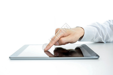 手触摸桌上的平板电脑屏幕图片