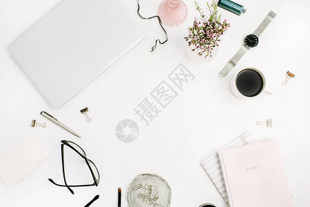 白色桌子上的柔和粉色笔记本笔记本电脑眼镜咖啡杯野花和配饰的框架图片