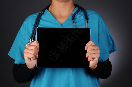 一名护士在她的躯干前拿着一台带有空白黑屏的平板电脑的特写镜头图片