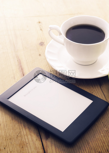 电子书阅读器和带晨光的咖啡杯图片