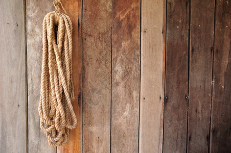 挂在木墙上的棕色绳子图片