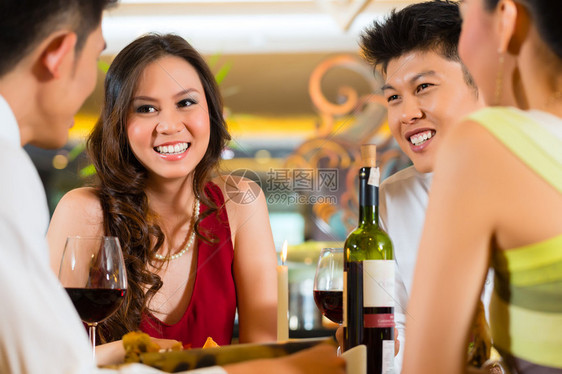 四个亚洲商人在优雅的俱乐部餐厅或酒店吃晚饭图片