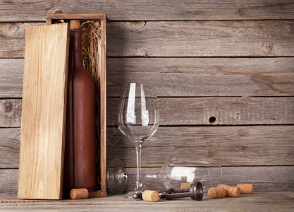 木桌上的红酒瓶和眼镜图片