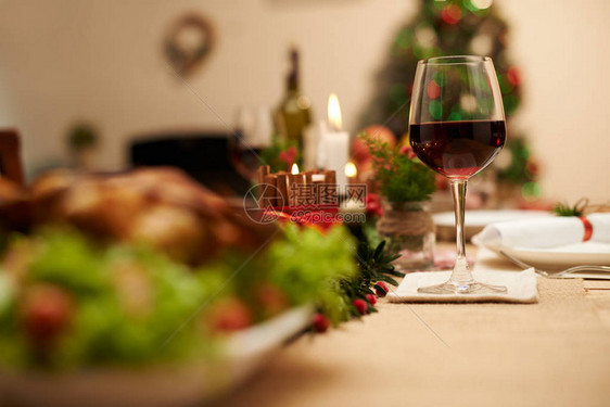 装饰圣诞桌葡萄酒杯和蜡烛及焰图片