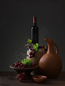 一瓶红酒水罐葡萄和木桶图片