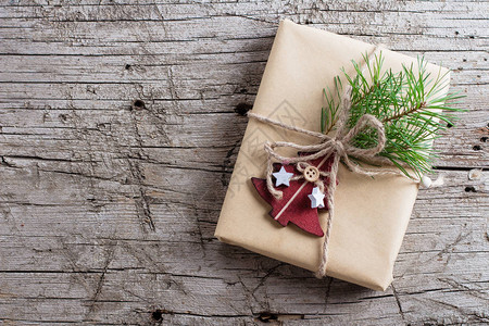 节日圣诞礼盒圣诞礼物与冷杉树枝和木桌上的红色木树玩具装饰顶视图片