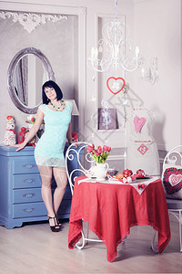 一位美丽的年轻女子的肖像站在她浪漫的厨房图片