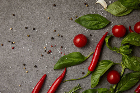 灰色桌子上美味的西红柿大蒜和辣椒的顶视图图片