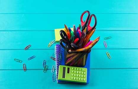 学校和办公用品学校背景彩色铅笔钢笔疼痛学校用纸和蓝色木背景的学生图片
