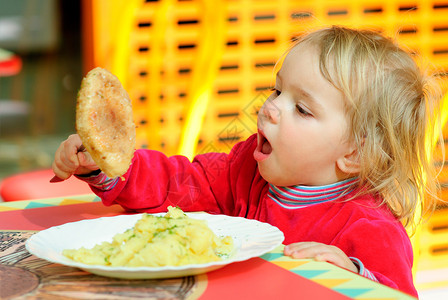 小孩子在小桌子后面吃大炸肉排背景图片