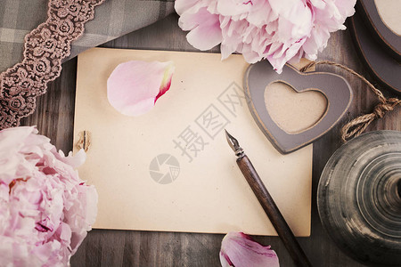 旧的空白纸背景与鲜花爱心钢笔和花边顶视图图片