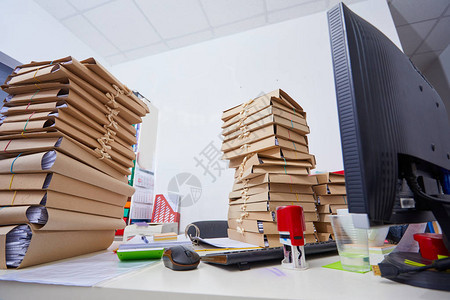 办公室办公桌上成堆的纸质文件图片