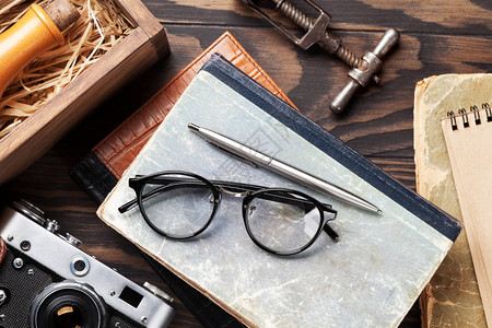 笔和笔记本带有古董物品的回溯表相机书籍眼镜酒瓶背景