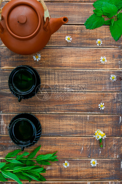 棕色茶壶靠近两杯黑茶图片