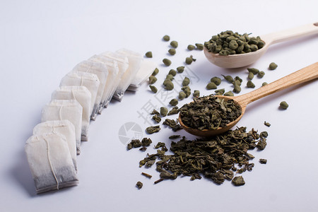 木勺和茶包中不同品种的叶茶图片