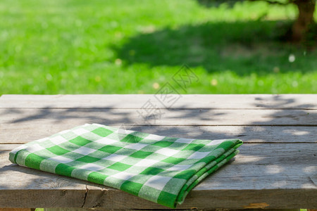 带桌布的空木花园桌绿色散景背图片