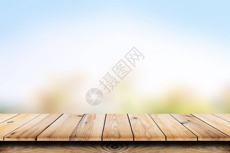 具有抽象蓝色自然背景的空木质桌用于显示或匹图片