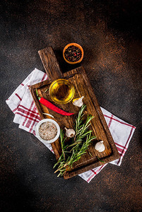 烹饪背景香草盐香料切板上的橄榄油深色生锈的背景复图片