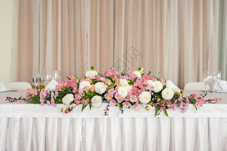 美丽的婚礼花卉装饰在餐厅的桌子上图片