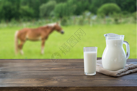 深色木桌面上的玻璃杯中的新鲜牛奶图片