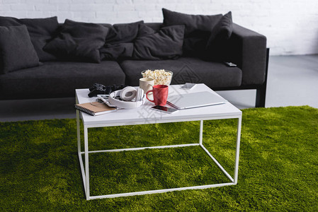 客厅里的灰色沙发和白色桌子绿色地毯图片