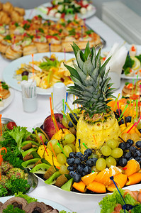 宴会甜品桌摆放着许多装饰过的水果盘图片