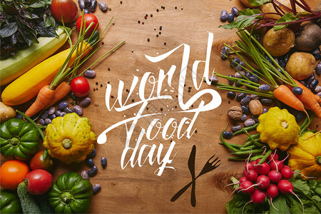 以世界粮食日为字母的木制桌上蔬菜和豆类图片