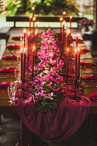 配有红蜡烛粉红色布和紫兰花图片