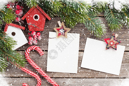 圣诞照片空白框鸟屋装饰和木制桌上的雪卷树您可到顶端图片