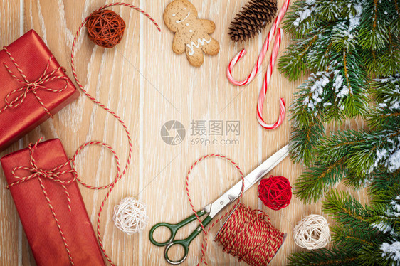 圣诞礼物包装和雪绒树木制桌背景图片