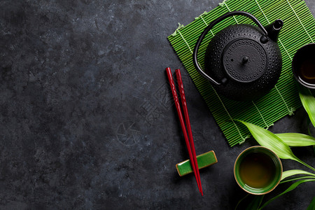 石桌上的绿茶和寿司筷子带有复制空背景图片