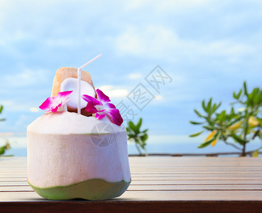 热带旅游目的地欢迎饮用绿椰子和兰花图片