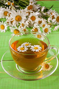 草药茶和新鲜的甘菊花在绿图片
