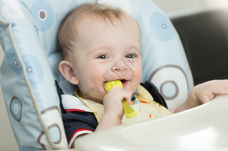 美丽的九个月婴儿的肖像男孩在吃图片