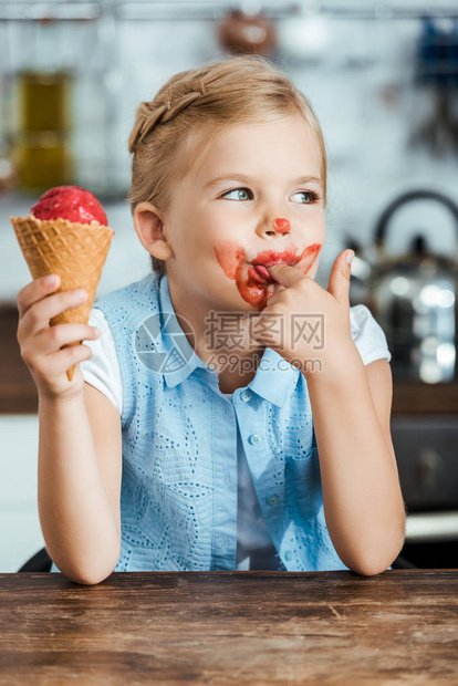 可爱的小孩吃甜冰淇淋和舔手指图片