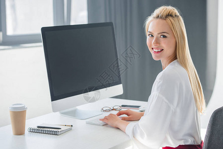 美丽的年轻女商人在办公室使用台式计算机工作时图片