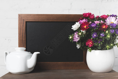 茶壶的近视花瓶中美丽的鲜花开图片