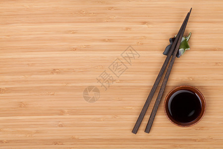 寿司筷子和酱油碗在竹桌之上图片