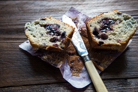 新鲜自制蓝莓松饼用老刀切成两半在图片