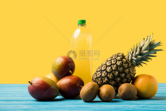 绿石木桌上塑料瓶中的新鲜热带水果和天然图片